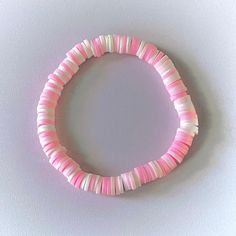 a pink and white beaded bracelet on a white surface