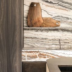 a wooden cutting board mounted to the side of a wall next to a sink in a bathroom