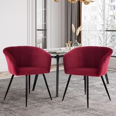 two red chairs sitting next to each other on top of a rug