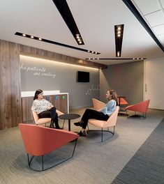 two women sitting in chairs talking to each other