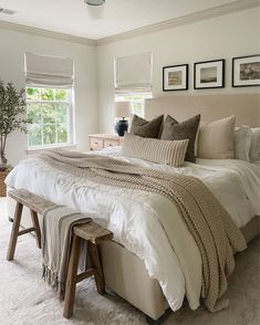 a large bed sitting in a bedroom next to two pictures on the wall above it