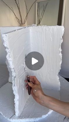 a person is painting a large piece of white paper