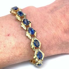 "Here we have an astonishing natural unheated untreated earth mined blue sapphire and fancy natural untreated champagne diamond bracelet in 14K yellow gold circa 1970.  This bracelet is startling to look at firstly because of the bold color contrast of blue and gold and then because of the large size and quality of each of the sapphires. The intense blue sparkle of the untreated sapphires is accentuated further by the generously proportioned wide geometric solid yellow gold links. In each link f Sapphire Bracelet With Prong Setting, Sapphire Gemstone Diamond Bracelet For Anniversary, Anniversary Sapphire Diamond Bracelet, Gold Sapphire Bracelets For Anniversary, Gold Sapphire Bracelet In Fine Jewelry Style, Sapphire Gemstone Bracelets For Anniversary, Gold Sapphire Bracelets Fine Jewelry, Anniversary Sapphire Gemstone Bracelets, Yellow Gold Sapphire Diamond Bracelet In Fine Jewelry Style