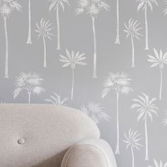 a couch in front of a wall with palm trees on it