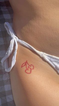 a close up of a person's stomach with a red tattoo on the side