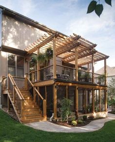 a large wooden house with stairs leading up to the second floor and covered patio area