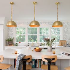 a kitchen with white counters and wooden stools next to an island in the middle