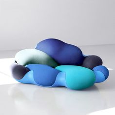 a blue and green couch sitting on top of a white table