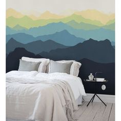 a bed sitting under a painting on the side of a wall next to a night stand