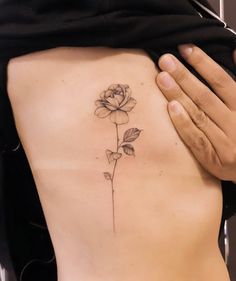 a woman's back with a tattoo on her stomach and a rose in the middle