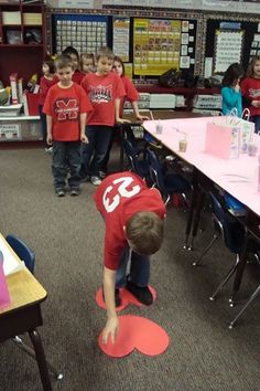 a kid on a red skateboard in a classroom