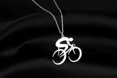 a silver necklace with a bike on it's back and the word bicycle written in white