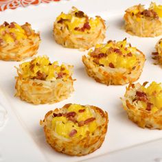 small appetizers are sitting on a white tray with orange and red designs in the background