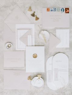 the wedding stationery is laid out neatly on top of the table, including an envelope and ring