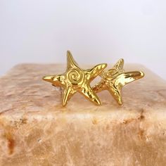 Experience the seaside vibes with our Starfish Earrings. These fun, statement earrings are perfect for adding a touch of playfulness to any outfit. Great for elevating your summer look! Materials: 18K Gold Plated Stainless steel - Tarnish Free Measurements: 25mm at widest Beach Star Charm Earrings, Beach Earrings With Star Charm, Ocean-inspired Star Earrings For The Beach, Gold Starfish Earrings For Beach, Star-shaped Ocean-inspired Earrings For Beach, Ocean-inspired Star Earrings For Summer, Ocean-inspired Star Earrings For Beach, Star-shaped Earrings With Star Charm For Beach, Ocean-inspired Starfish Earrings For Summer