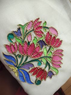 an embroidered flower design on a white cloth