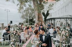 a bride and groom kissing in front of an outdoor wedding ceremony with chairs set up for them