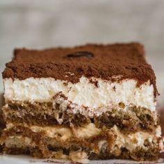 a piece of cake on a white plate with chocolate shavings and frosting