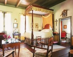 a bedroom with four poster bed and chairs