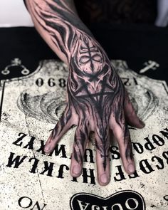 a tattooed hand on top of a table