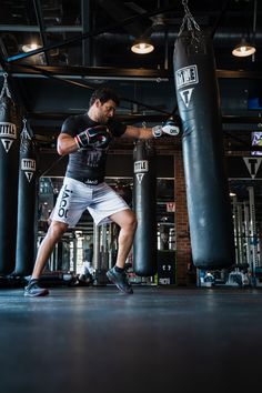 a man is practicing his boxing skills in a gym with punching gloves on the ground