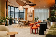 a room with chairs, tables and potted plants