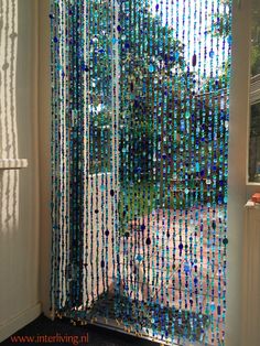 there is a curtain made out of beads on the outside of a door that has been decorated with blue and green beads