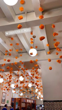 the ceiling is decorated with orange paper flowers