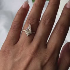 a woman's hand with a diamond ring on it