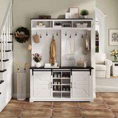 an entryway with white cabinets and black counter tops, brown tile flooring and stairs