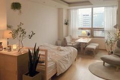 a bed room with a neatly made bed next to a desk and chair near a window