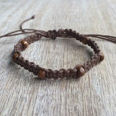 two brown bracelets with beads are sitting on a table