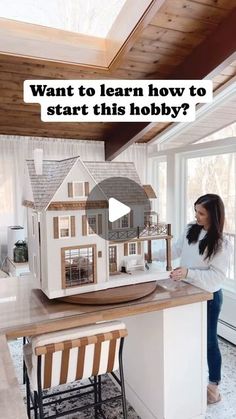 a woman standing in front of a model house