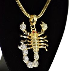 Scorpion shape pendant on a Franco chain. Pendant encrusted with dazzling stones. Scorpion has intriguing red stone eyes. Big pendant measures 3" tall x 2" wide. 36" x 4MM with lobster claw clasp. High quality gold finish over base metal. 100% FREE SHIPPING in USA. Order now! Oc Outfits, Big Pendant, Red Stone, Chain Pendant, Base Metal, Scorpion, Gold Finish, Statement Necklace, Chain Necklace