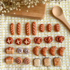 hotdogs and buns are arranged on a table next to a wooden spoon