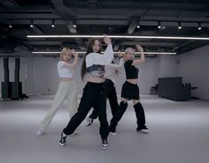 three women in black and white outfits are posing for the camera with their arms up