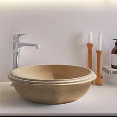 a bowl shaped sink sitting on top of a counter next to a faucet