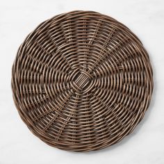 a brown wicker plate sitting on top of a white table