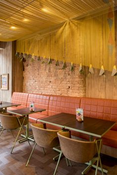 an empty restaurant with orange booths and wooden tables