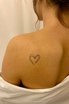 a woman with a heart tattoo on her shoulder