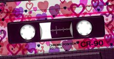 an old school cassette with hearts on the side and two white circles at the top