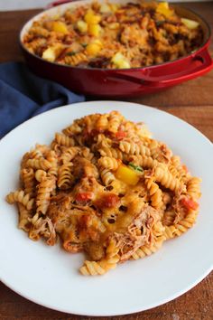 a white plate topped with pasta next to a casserole dish