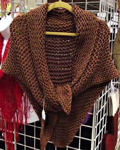 a brown knitted shawl hanging on a rack in a room with other items