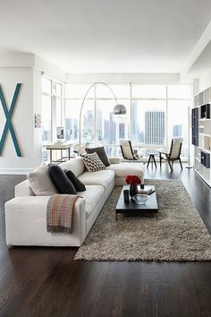 a living room filled with furniture and tall windows