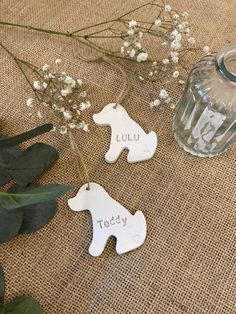 two wooden ornaments sitting on top of a table next to flowers and a glass jar