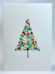 a white card with a colorful christmas tree on it