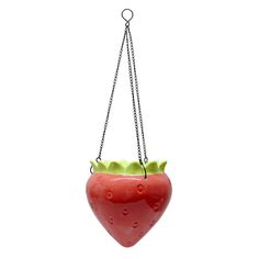 a plastic strawberry hanging from a chain on a white background