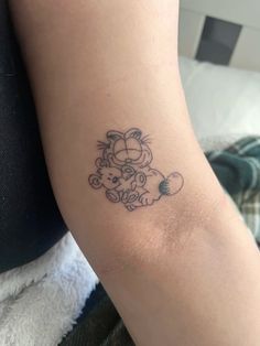 a small tattoo on the arm of a person with a teddy bear in it's arms