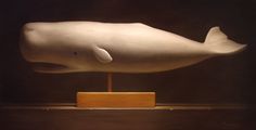 a sculpture of a white whale on a wooden stand