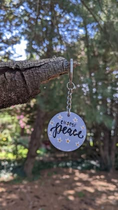 a keychain that says choose peace hanging from a tree